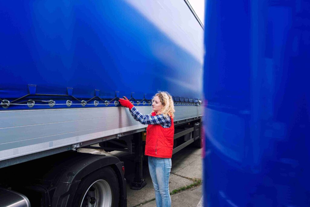 driver securing the side curtain of the truck