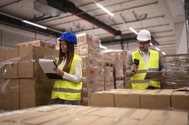 Warehouse workers using barcode scanner tablet checking goods inventory