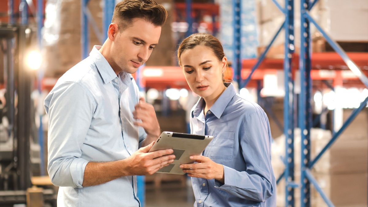 Two warehouse managers in front of inventory storage racks
